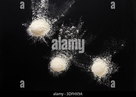 Sprinkled wheat flour splash spots on black background Stock Photo