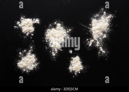 Sprinkled wheat flour splash spots on black background Stock Photo