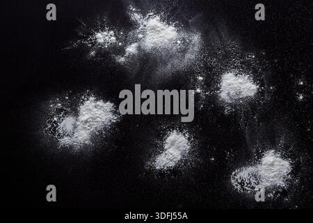 Sprinkled wheat flour splash spots on black background Stock Photo
