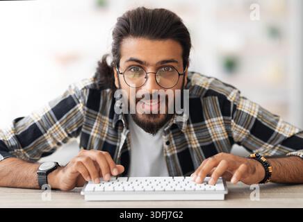 Young middle-eastern man programmer sitting at worktable Stock Photo