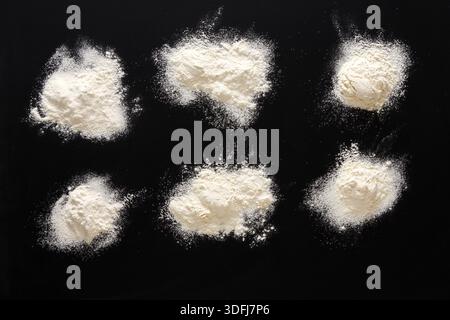 Sprinkled wheat flour splash spots on black background Stock Photo