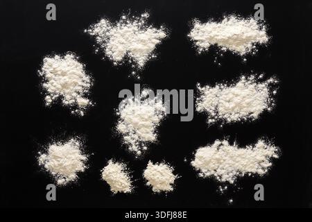 Sprinkled wheat flour splash spots on black background Stock Photo