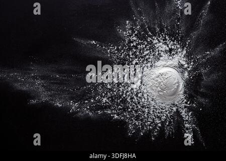 Sprinkled wheat flour splash spots on black background Stock Photo