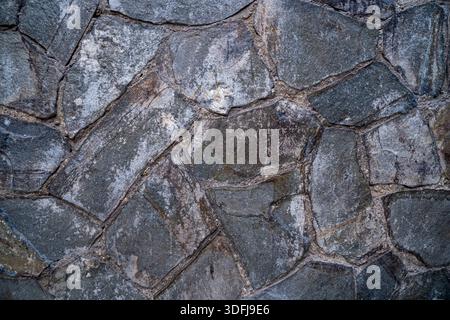 Natural grey stone wall texture with irregular shapes. Rustic masonry background for architectural and landscaping design Stock Photo
