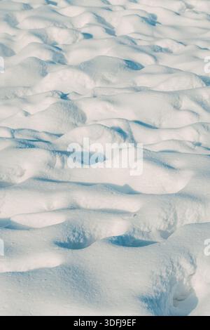 Wind-sculpted snow surface with ripples and shadows texture, selective focus Stock Photo