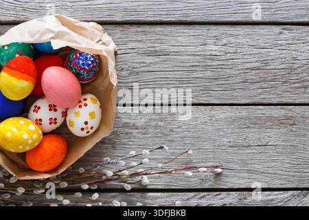 Colorful Easter Eggs in a Basket on Rustic Wooden Table With Spring Decorations Stock Photo