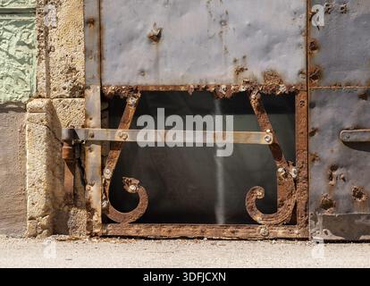 Rusty metal gate with decorative elements and peeling paint Stock Photo
