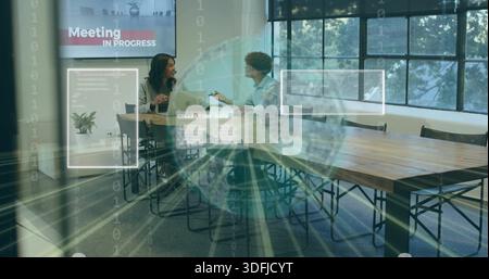 Talking coworkers in suits reviewing laptop at meeting room, screen showing Meeting IN PROGRESS HUD Stock Photo