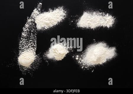 Sprinkled wheat flour splash spots on black background Stock Photo