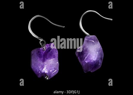 Natural amethyst silver earrings isolated on black background Stock Photo