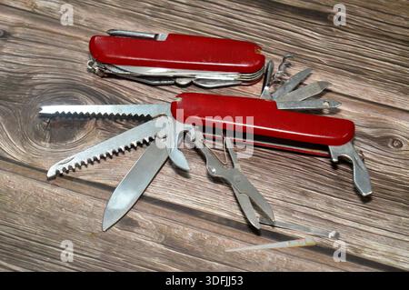 Two multi-tool pocket army knifes, a compact, folding device that combines multiple functions (tools) into a single, portable unit, screwdriver, can o Stock Photo