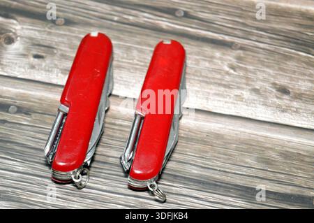 Two multi-tool pocket army knifes, a compact, folding device that combines multiple functions (tools) into a single, portable unit, screwdriver, can o Stock Photo