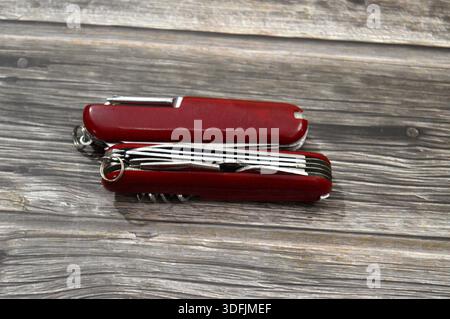 Two multi-tool pocket army knifes, a compact, folding device that combines multiple functions (tools) into a single, portable unit, screwdriver, can o Stock Photo