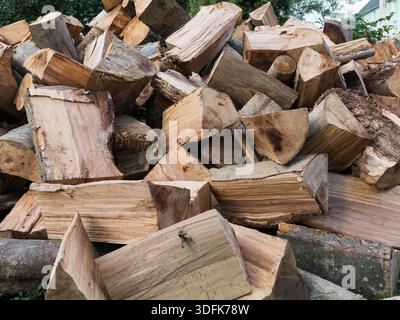 Close-up of firewood logs piled in a large heap, showing rough bark, cut ends, and natural textures used for heating and rustic backgrounds Stock Photo