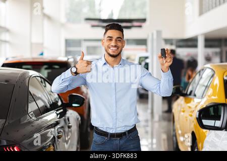 Handsome arabic guy showing car key and thumb up Stock Photo