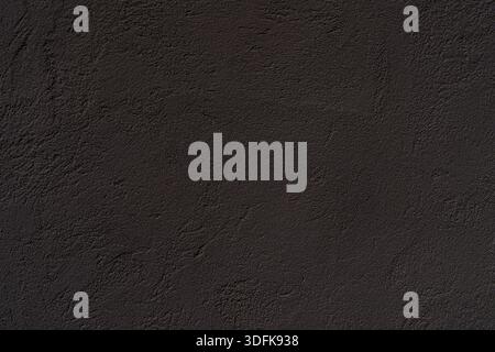 Texture of an old black plastered wall. Abstract construction background. Stock Photo