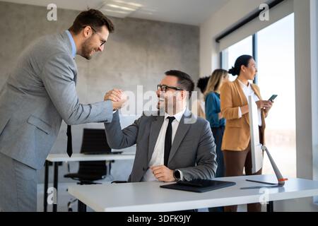 Young business people shaking hands in office. Handshake, finishing successful meeting. Stock Photo