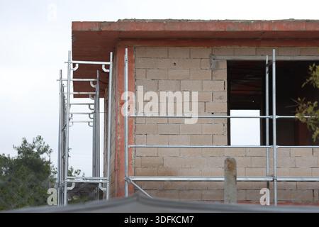 Close-Up of Unfinished Concrete Block Building with Metal Scaffolding and Exposed Structural Elements Stock Photo