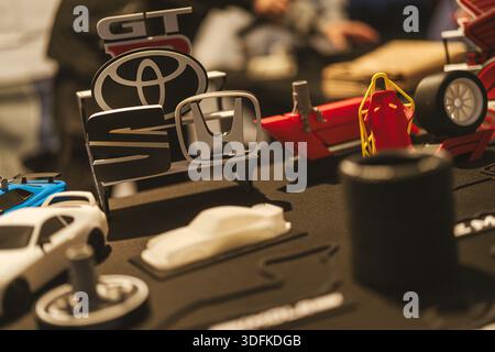 Imola, italy 01 january 2026: displaying 3d printed car logos including toyota, honda, and seat, alongside various automotive prototype models and par Stock Photo