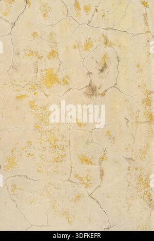 Yellow cracked paint on the wall. Abstract design background. Stock Photo