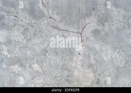 Cracks on the white plaster wall. Abstract design background. Stock Photo