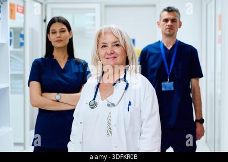 Healthcare professionals in a modern clinic standing together confidently during a busy workday Stock Photo