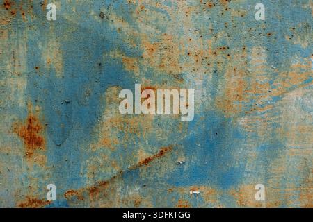 Rusted blue metal surface with peeling paint and corrosion patterns, showing industrial decay and weathered texture Stock Photo