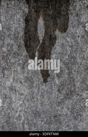 Grey concrete wall with vertical water stains and natural weathering, creating an abstract urban texture Stock Photo