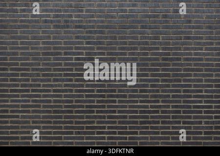 Grey brick wall with uniform horizontal masonry pattern, clean architectural texture suitable as modern urban background Stock Photo