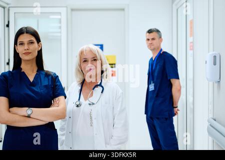 Healthcare professionals in a modern medical facility collaborating on patient care in a well-lit hallway Stock Photo