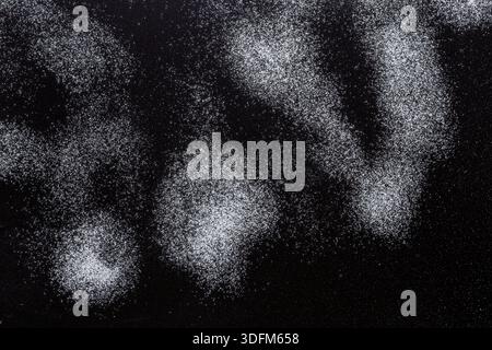 Sprinkled wheat flour splash spots on black background Stock Photo