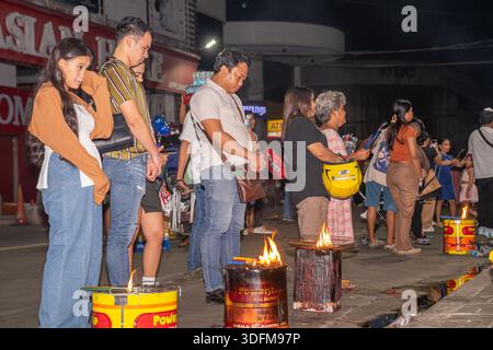 burning barrels used for joss paper or incense, practice, local traditions blending with Catholic. Christmas religious ceremony in Cebu, Philippines Stock Photo