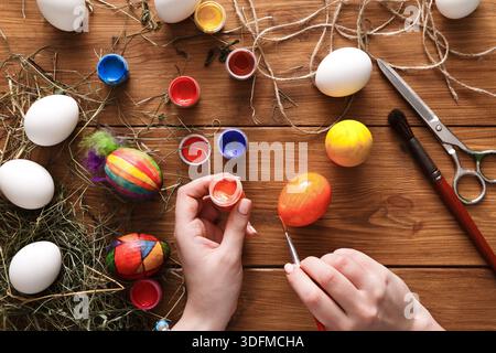 Creative Egg Decorating Activity With Vibrant Paints and Tools on a Rustic Wooden Table Stock Photo