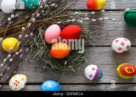 Colorful Easter Eggs Arranged in a Nest on a Wooden Surface With Decorative Branches Stock Photo
