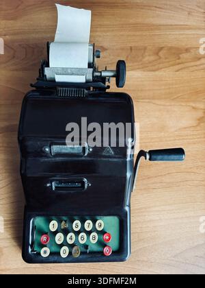 Vintage mechanical calculator used to perform basic arithmetic calculations and print the results on a roll of paper. Mechanical adding machine. Stock Photo