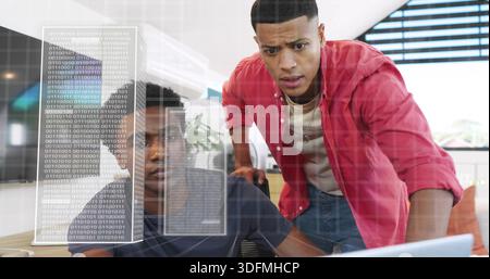 Collaborating two men in navy tee, red shirt reviewing laptop screen at office, with binary overlay Stock Photo