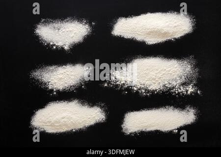 Sprinkled wheat flour splash spots on black background Stock Photo