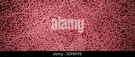 Textured dark red upholstery textile background with abstract patterned fabric surface, macro backdrop with vignette. Stock Photo