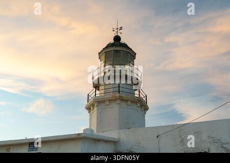 View of Armenistis Lighthouse standing tall against a soft, pastel sky, its weathered white structure a beacon of history and guidance, Armenistis, Mi Stock Photo