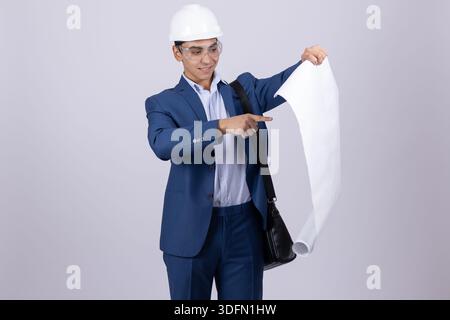 Professional man in suit and helmet pointing at building plans Stock Photo
