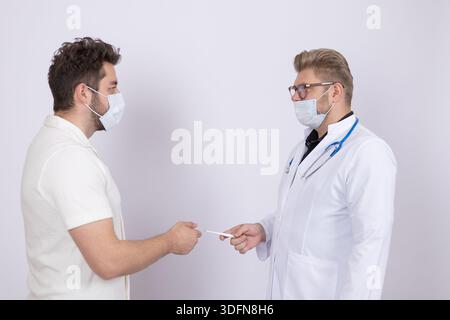 Two doctors in medical masks shaking hands after successful medical operation Stock Photo