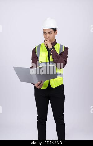 Professional Engineer in Safety Equipment Using Laptop for Project Management Stock Photo