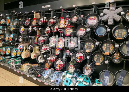Liepaja, Latvia- 07 January, 2026: Large assortment of frying pans and cookware hanging on shelves in a modern kitchenware store interior Stock Photo