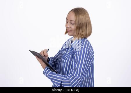 Professional Woman Writing on Clipboard and Planning Daily Tasks in Studio Stock Photo