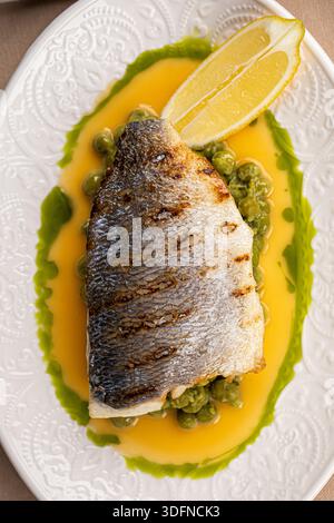 Pan seared sea bass with green pea puree Stock Photo