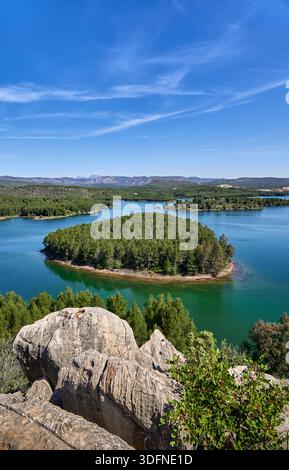 Aerial view of a serene reservoir surrounded by arid hills and sparse ...
