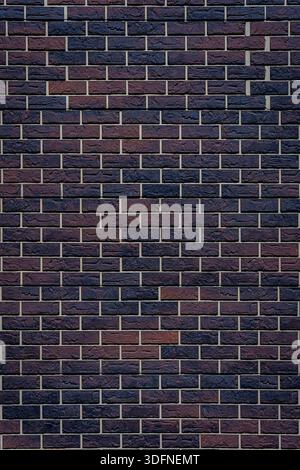 The brick wall is made of brown and black bricks. The bricks are arranged in a pattern. Stock Photo