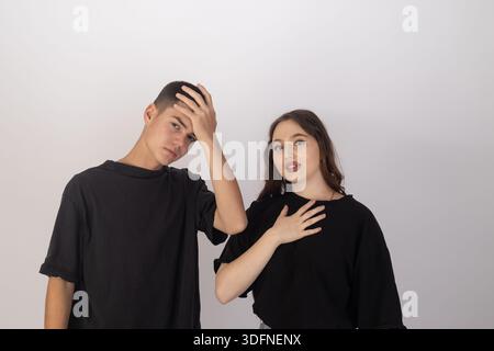 Young Man and Woman Expressing Stress and Headache with Hands on Head Stock Photo