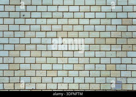 Wall of vintage bricks covered with cracked glaze. Bricks are arranged in a pattern. Stock Photo