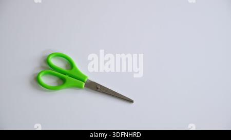 Scissors with green handles isolated on white background. Childrens stationery. High quality photo Stock Photo
